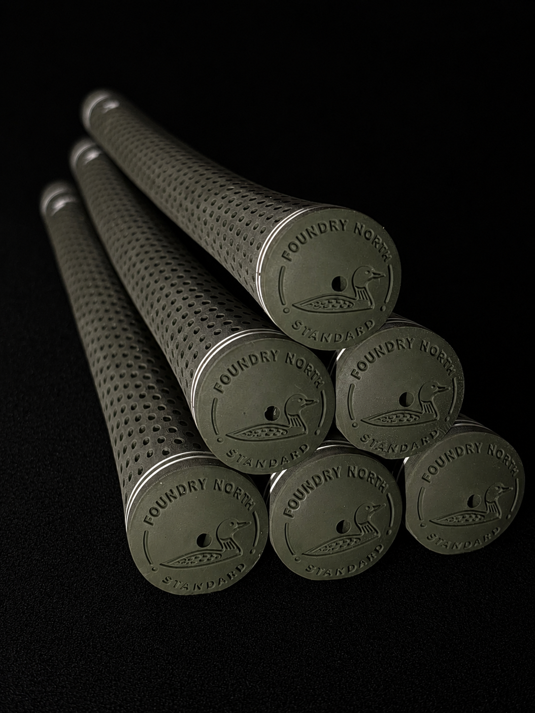 Stack of Foundry North Olive Drab golf grips on a clean black background